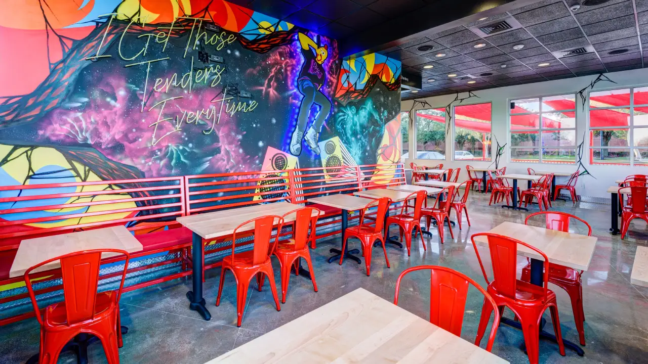 Interior image of Dave's Hot Chicken in Missouri City, Texas. The restaurant dining room features a one of a kind brightly painted mural and open design.
