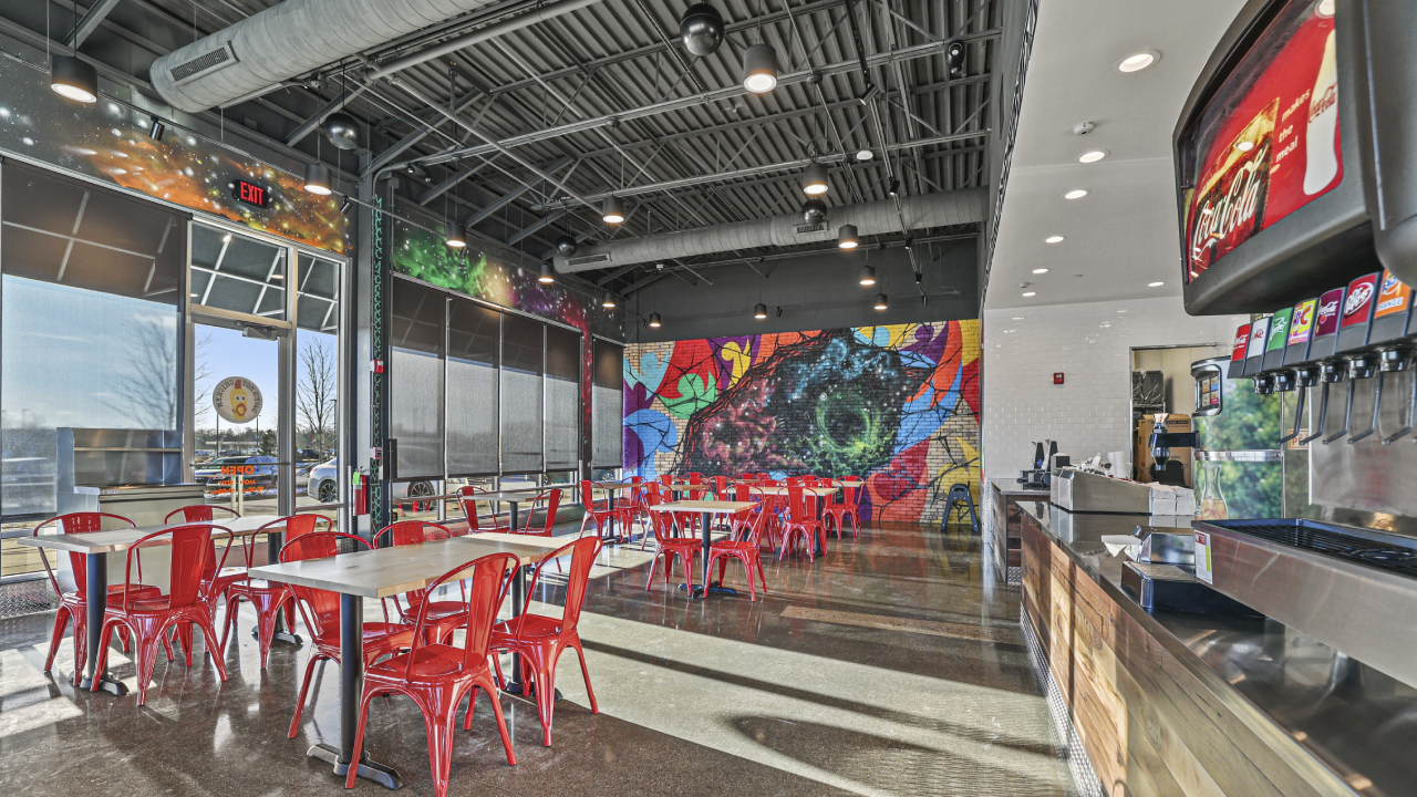 Wide photo of the dining room with fountain drinks on the right side and Dave's signature graffiti wall in the distance at Dave's Hot Chicken in Menomonee.