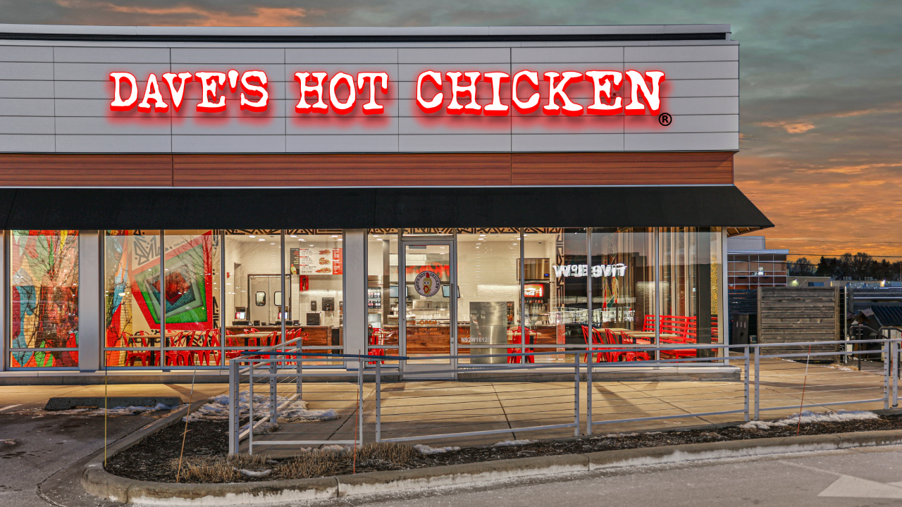 Exterior image of Dave's Hot Chicken in Menomonee, WI from the side during sunset.