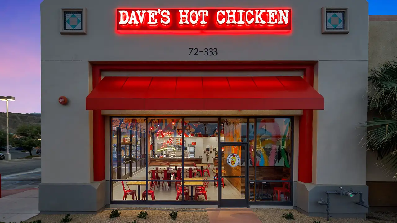 Exterior photo of dave's hot chicken in Palm Desert on CA-111 at night.
