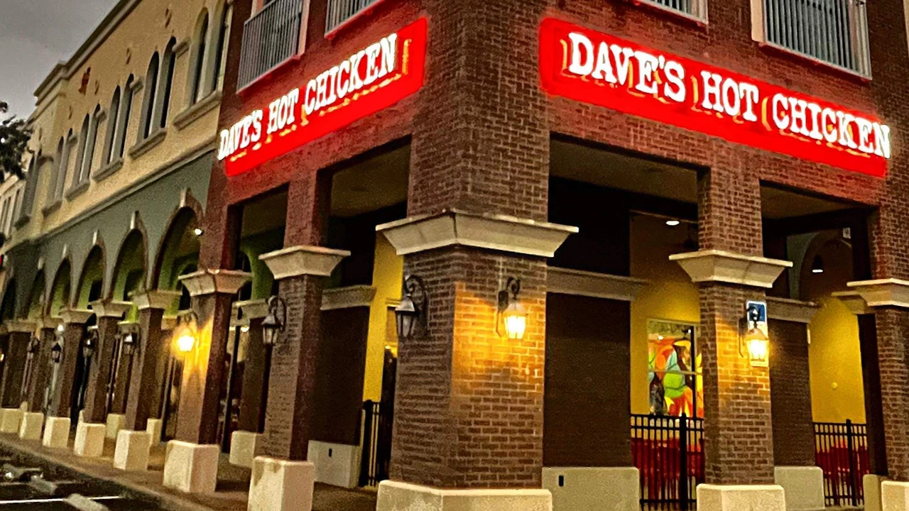 Exterior of Dave's Hot Chicken in Altamonte Springs, FL, featuring a red neon sign and old-style columns on a brick building