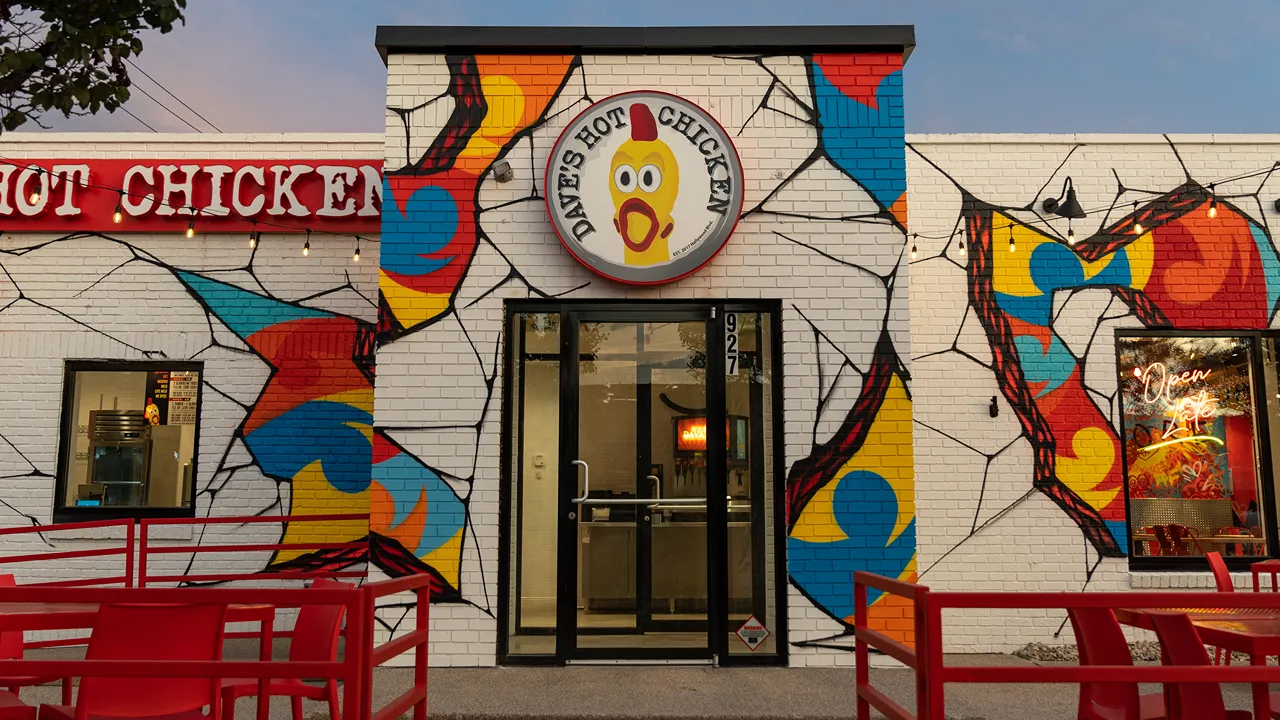 Entrance of Dave's Hot Chicken on Broad Ripple Ave, Indianapolis, with vibrant exterior murals and signage.