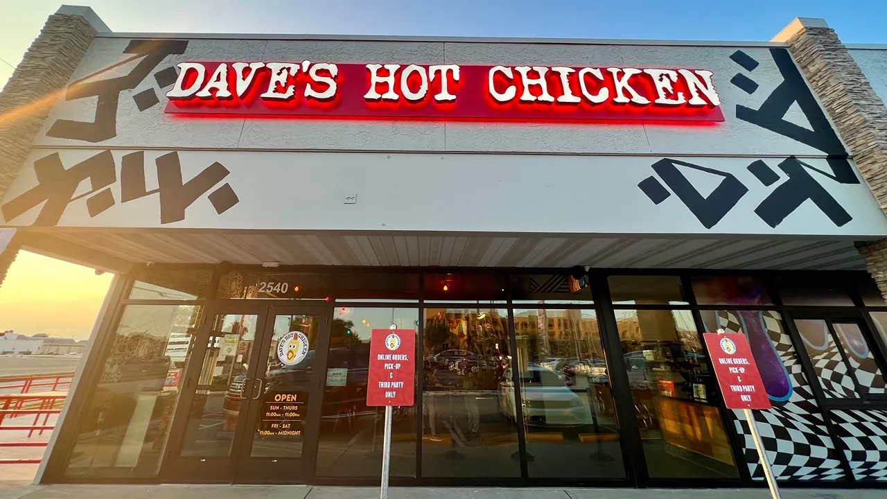 Exterior view of Dave's Hot Chicken with bright signage on E. Fowler Ave, Tampa, FL near USF.