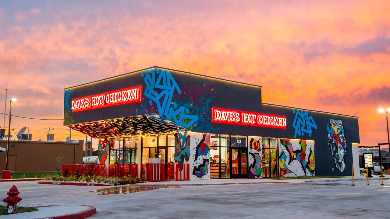 Exterior view of Dave's Hot Chicken with bold graffiti murals and red neon signage on E. Trenton Rd, Edinburg, TX