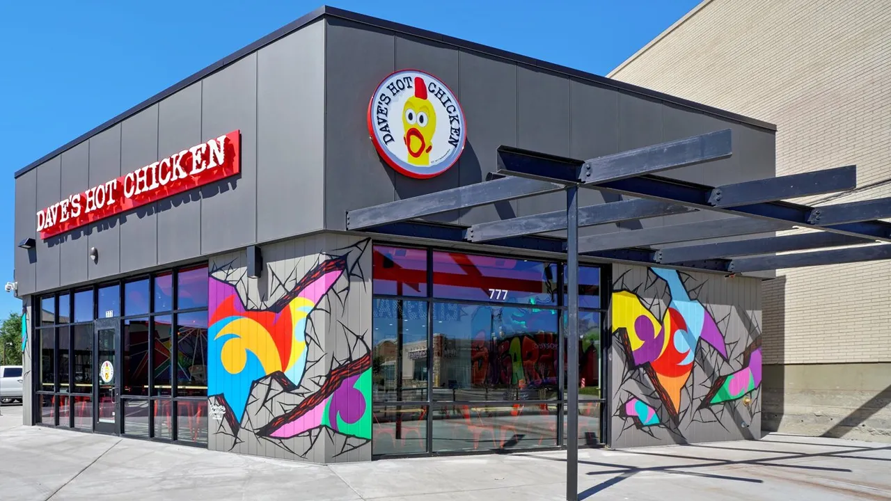 Exterior of Dave’s Hot Chicken on East 2100 South - Sugar House District, Salt Lake City, UT, featuring modern design and vibrant street art on the walls.