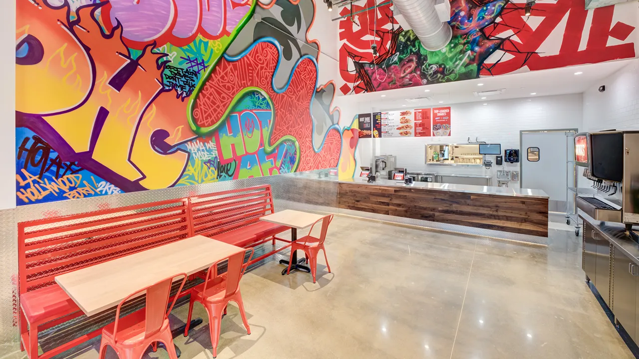 Interior of Dave's Hot Chicken on Eastfield Dr, Webster, TX, Baybrook location showing seating area with graffiti wall art.