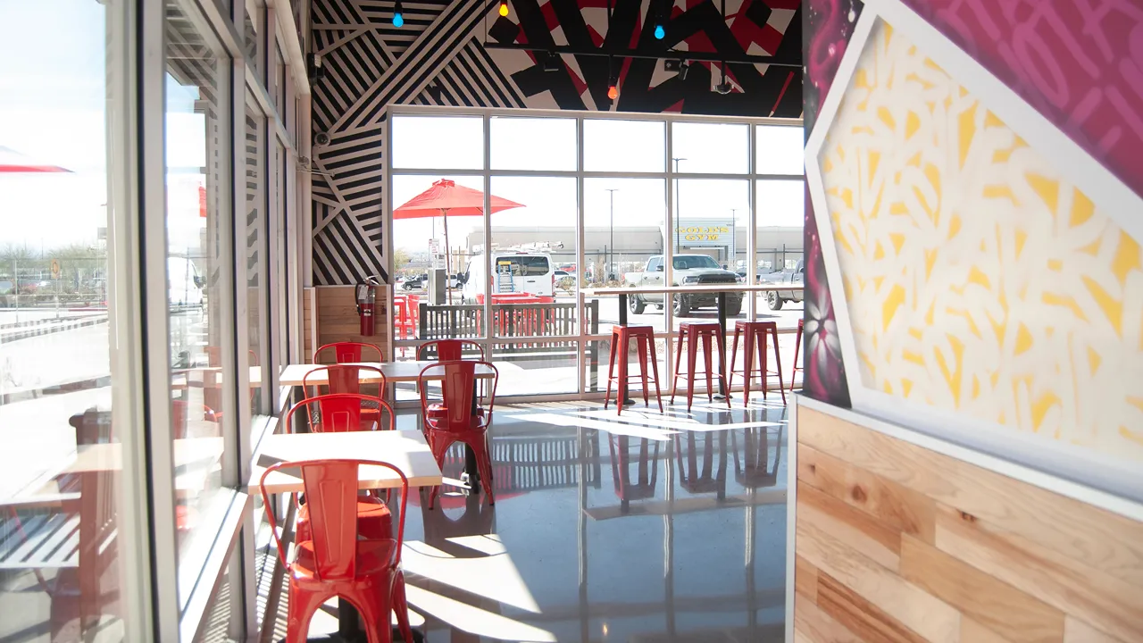 Bright window seating with red chairs and stools at Dave's Hot Chicken in El Paso, TX. TX., Eastlake Blvd.