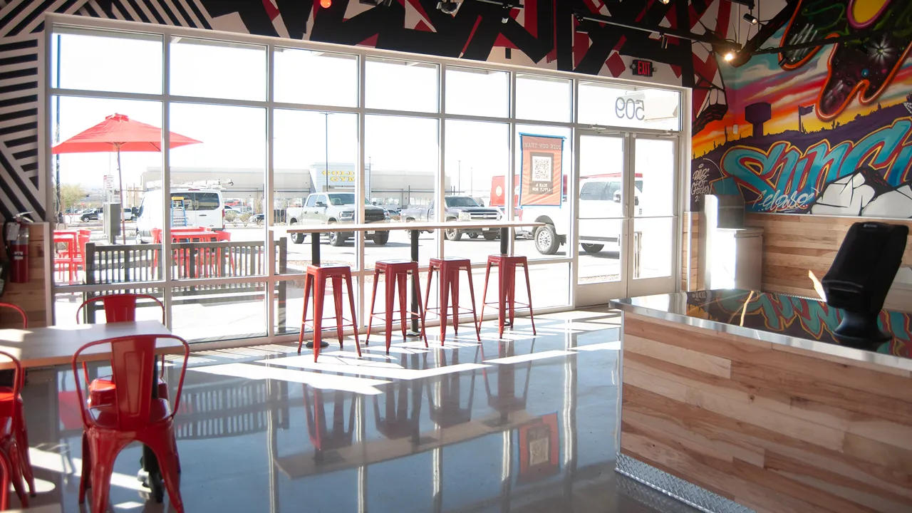 Interior view with colorful murals and seating by the windows at Dave's Hot Chicken in El Paso, TX.