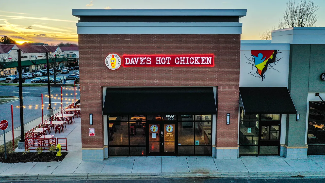 Exterior front view of Dave’s Hot Chicken at J.M. Keynes Drive, University Place, Charlotte, NC, with outdoor seating area.