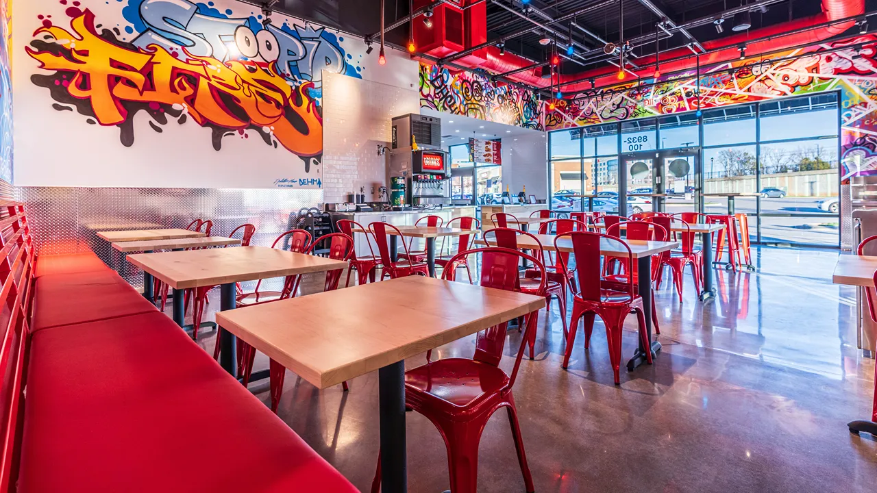 Indoor seating area at Dave’s Hot Chicken, J.M. Keynes Drive, Charlotte, NC, with views of the front entrance and vibrant decor.