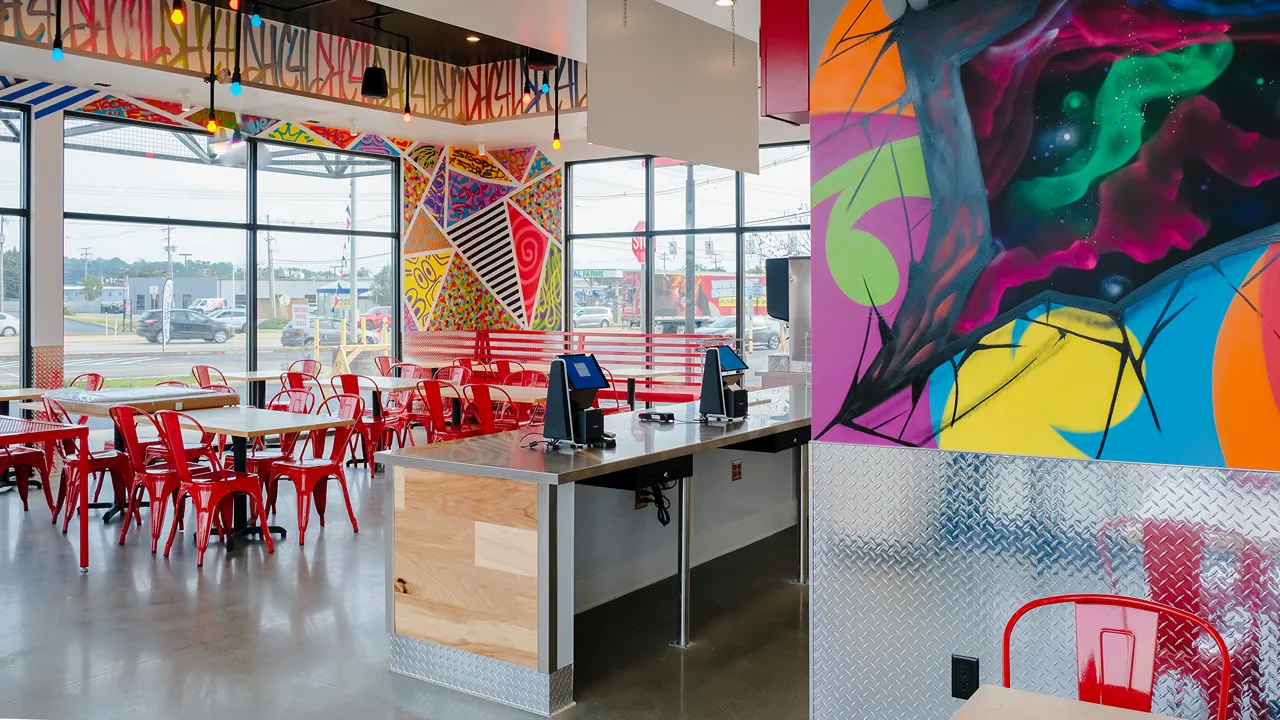 View of the counter and seating area with vibrant wall art at Dave's Hot Chicken, Loucks Rd., York, PA.