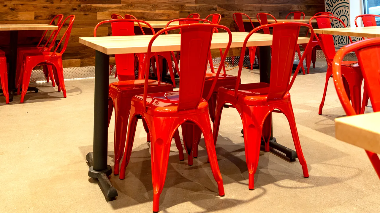 Close-up of red seating area and tables at Dave’s Hot Chicken on Massachusetts Ave, Indianapolis, in the Penrose district.