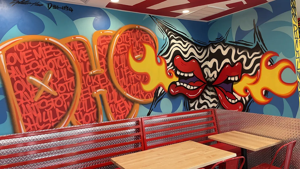 Graffiti wall art inside Dave's Hot Chicken on Mystic Valley Pkwy, Medford, MA, featuring bold red lettering and vibrant designs.