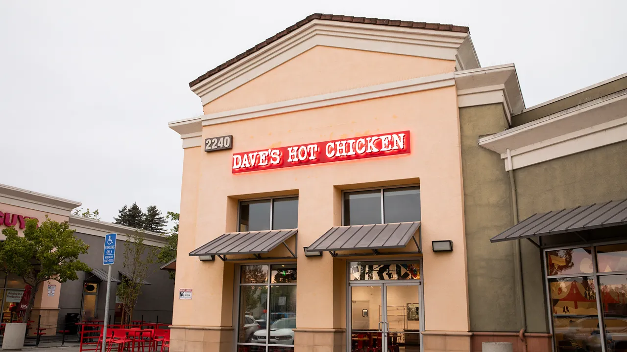 Front exterior of Dave's Hot Chicken on Mendocino Avenue in Santa Rosa, CA, featuring bright neon signage and outdoor seating.