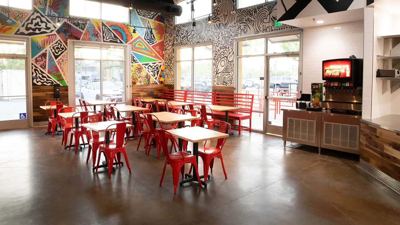 Beverage station near the dining area with bold wall murals inside Dave's Hot Chicken on Mendocino Avenue in Santa Rosa, CA.