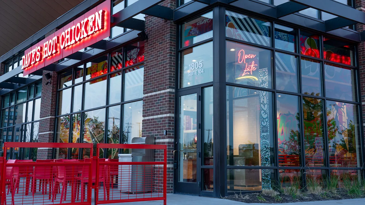 Front view of Dave's Hot Chicken location on Plymouth Rd, Minnetonka, MN with large windows and outdoor seating.