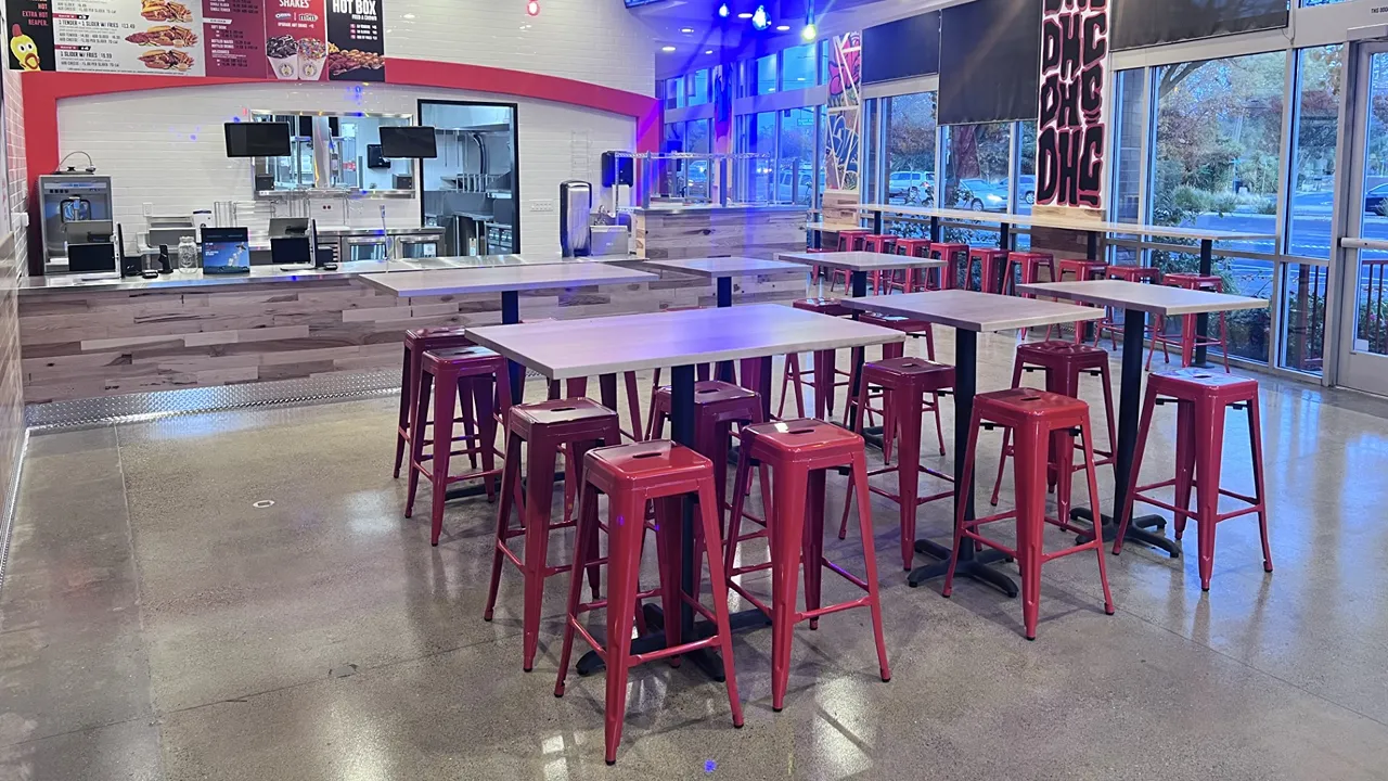 Interior seating with high stools and tables near the counter at Dave's Hot Chicken on Monument Blvd, Pleasant Hill, CA.