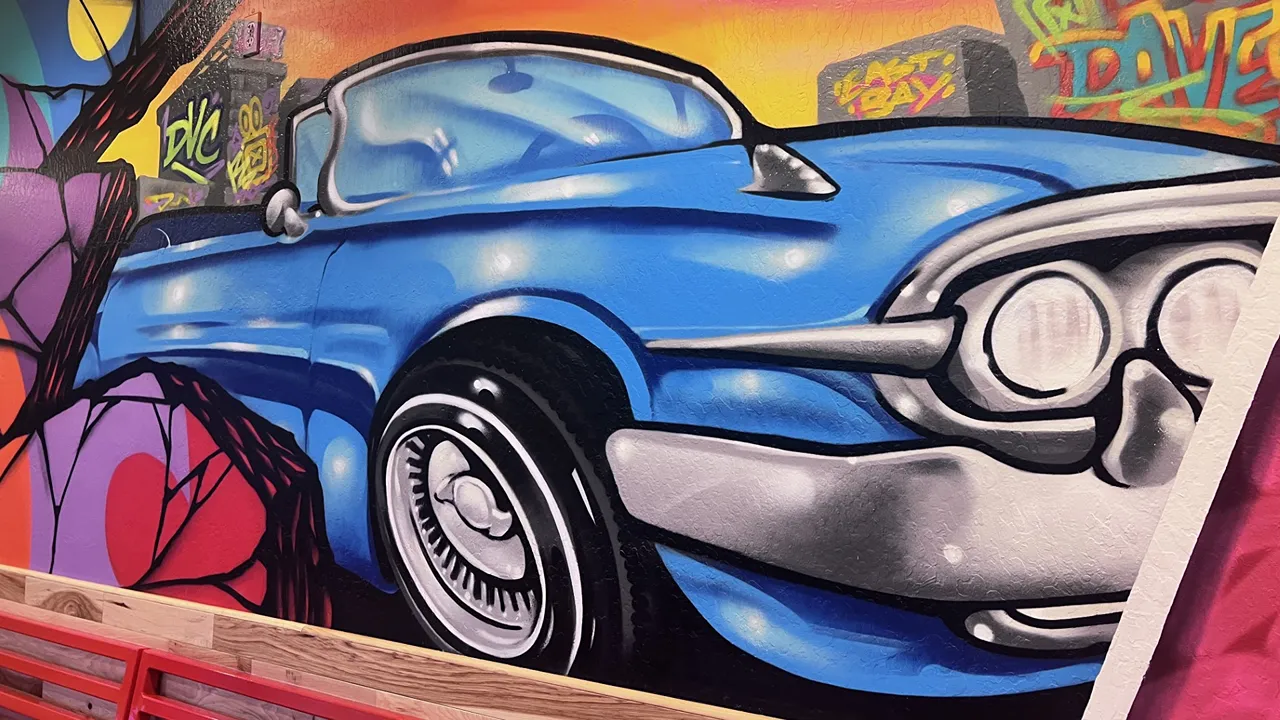 Wall art of a classic blue car at Dave's Hot Chicken on Monument Blvd, Pleasant Hill, CA