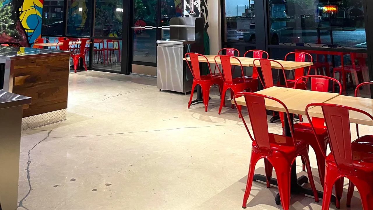 Dining area with red chairs and tables inside Dave's Hot Chicken on N. Alafaya Trail, Waterford Lakes, Orlando, FL.