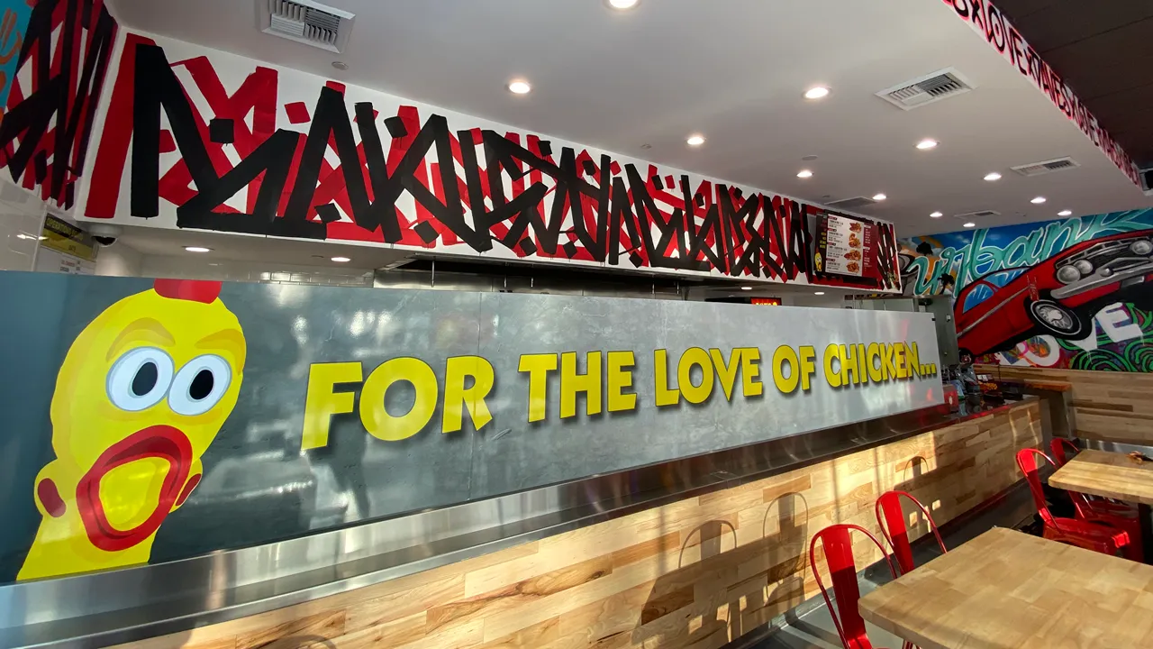 Interior of Dave's Hot Chicken on North Victory Place, Burbank, CA, featuring graffiti art with the text 'For the love of chicken'.