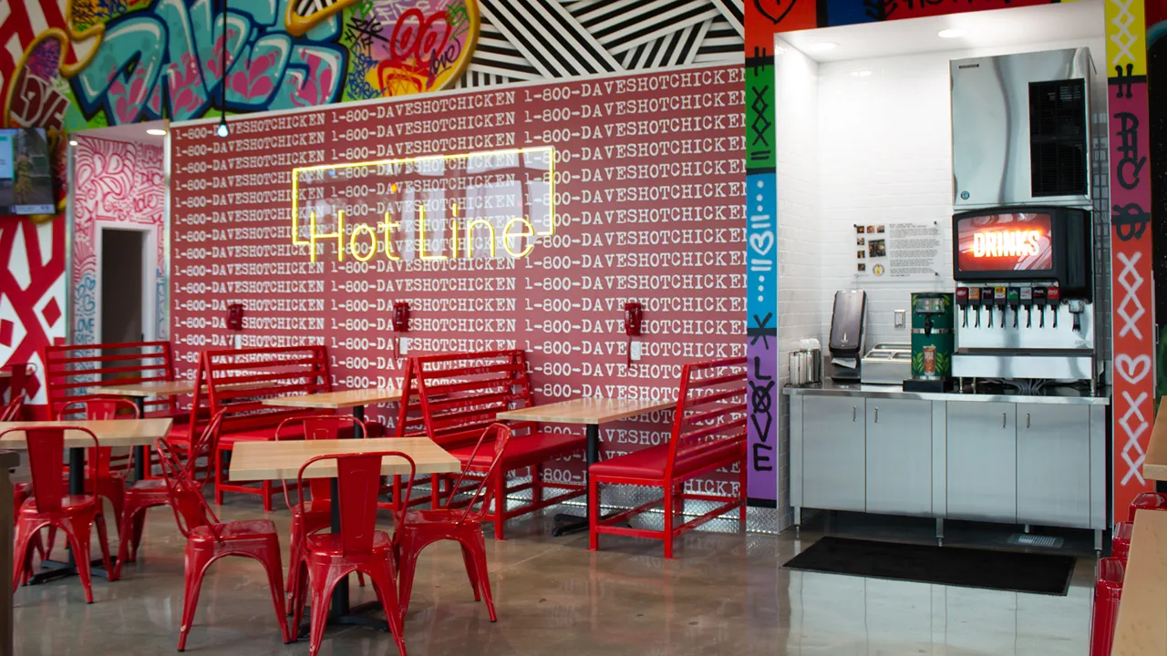 Drink station, seating and colorful wall art inside Dave's Hot Chicken on Pawnee Dr in Chisholm Creek, Oklahoma City, OK.