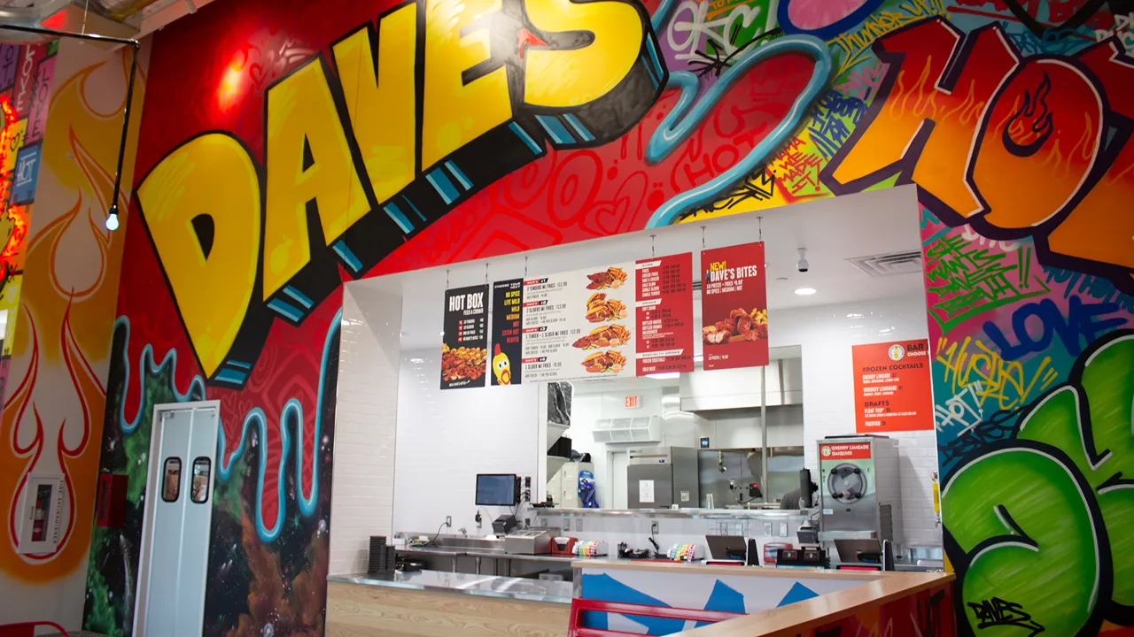 View of the counter and menu boards with vibrant graffiti art with the word 'Daves', at Dave's Hot Chicken in Chisholm Creek, Oklahoma City, OK.