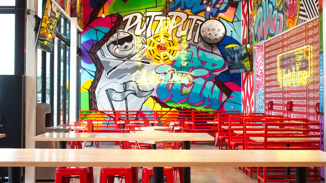 Bright neon wall art and seating inside Dave's Hot Chicken located in Chisholm Creek, Oklahoma City, OK.