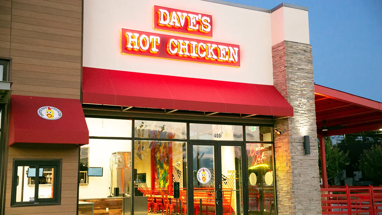 Front facade of Dave's Hot Chicken on Preston Rd, Plano, TX - Frisco, with bright signage and outdoor patio.