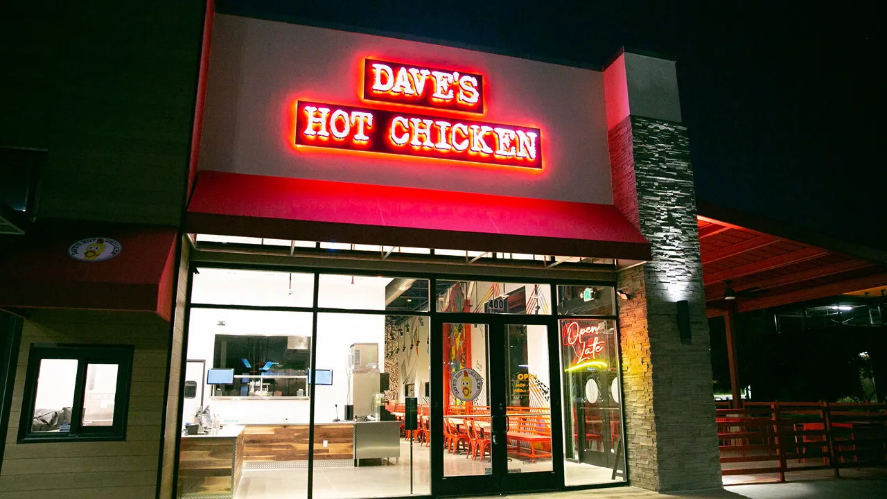 Exterior of Dave's Hot Chicken on Preston Rd, Plano, TX - Frisco location, glowing neon red signage at night.