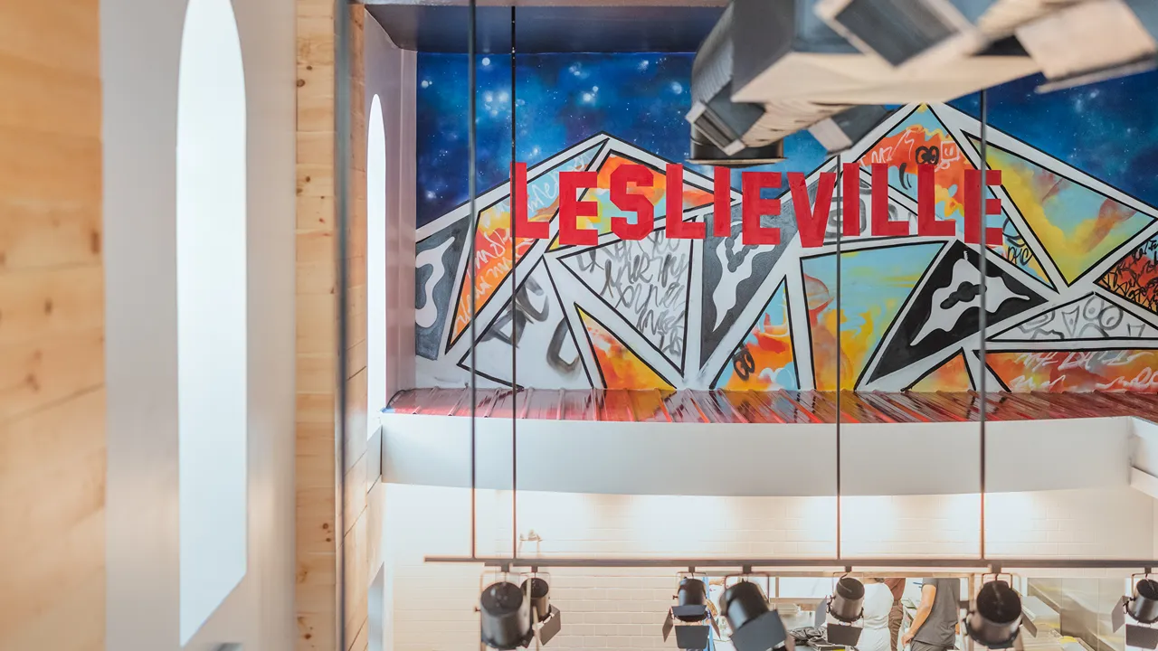 Interior view of Dave's Hot Chicken in Leslieville, Toronto, ON, showing colorful artwork and the Leslieville mural.