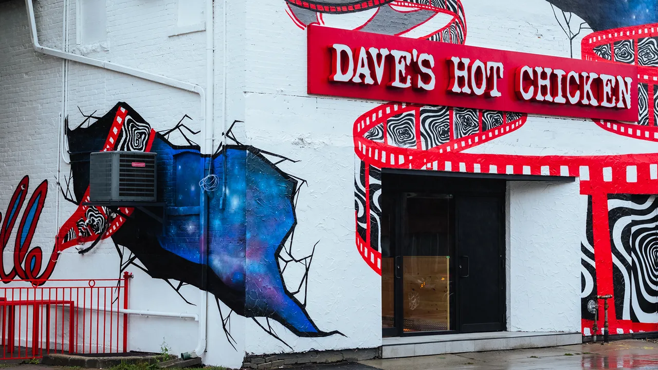 Side view of Dave's Hot Chicken in Leslieville, Toronto, ON, showing the exterior mural and signage.