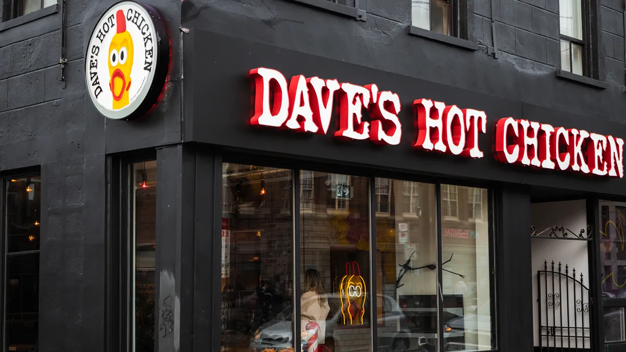 Exterior view of Dave's Hot Chicken on Queen St. in the Parkdale neighborhood of Toronto, ON during the day.