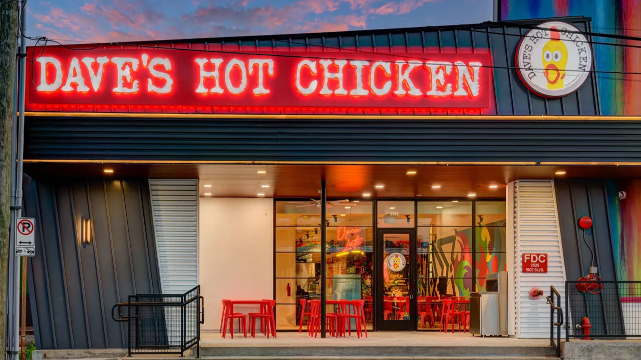 Exterior view of Dave's Hot Chicken with bright neon signage at Rice Blvd, Houston, TX.