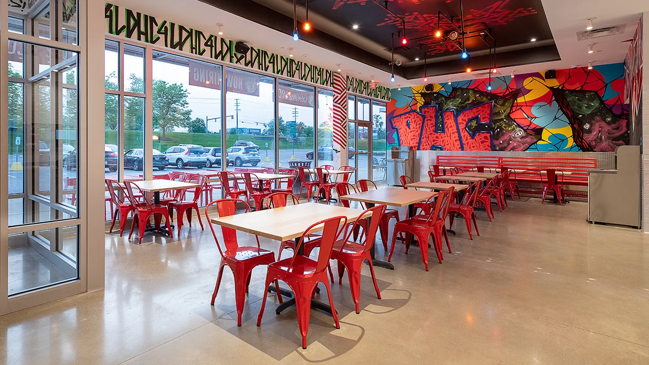 Seating with tables and wall art at Dave's Hot Chicken on Richmond Rd, Warrensville Heights, OH.