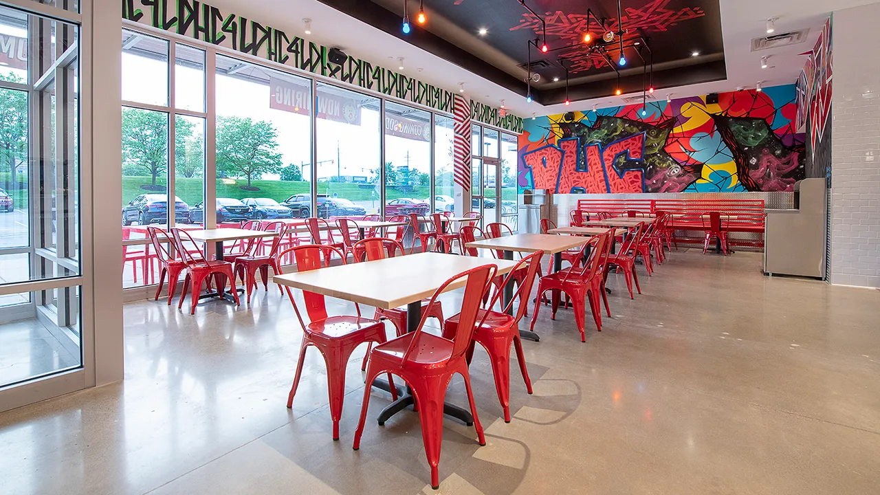 Interior seating area of Dave's Hot Chicken on Richmond Rd, Warrensville Heights, OH, with view of the outside.