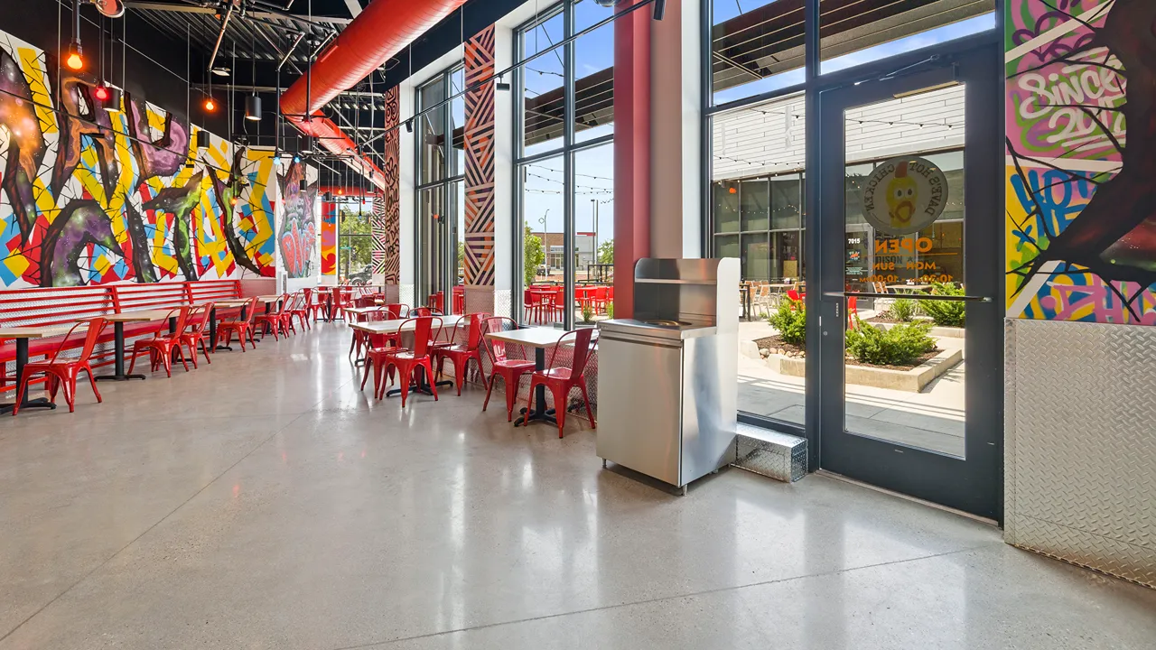 Restaurant dining area with colorful wall art inside Dave's Hot Chicken on Sligo Drive, Madison, WI, highlighting bold graffiti-style murals.