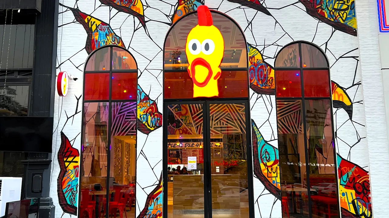 Exterior view of Dave's Hot Chicken on Tahliah Street in Riyadh, showing the vibrant entrance with graffiti art.