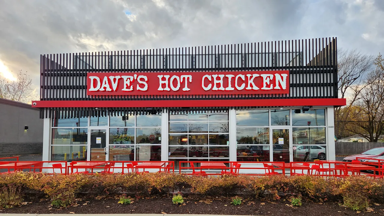 Exterior view of Dave's Hot Chicken on Niagara Falls Blvd, Tonawanda, NY, near Buffalo, showcasing the storefront at dusk.