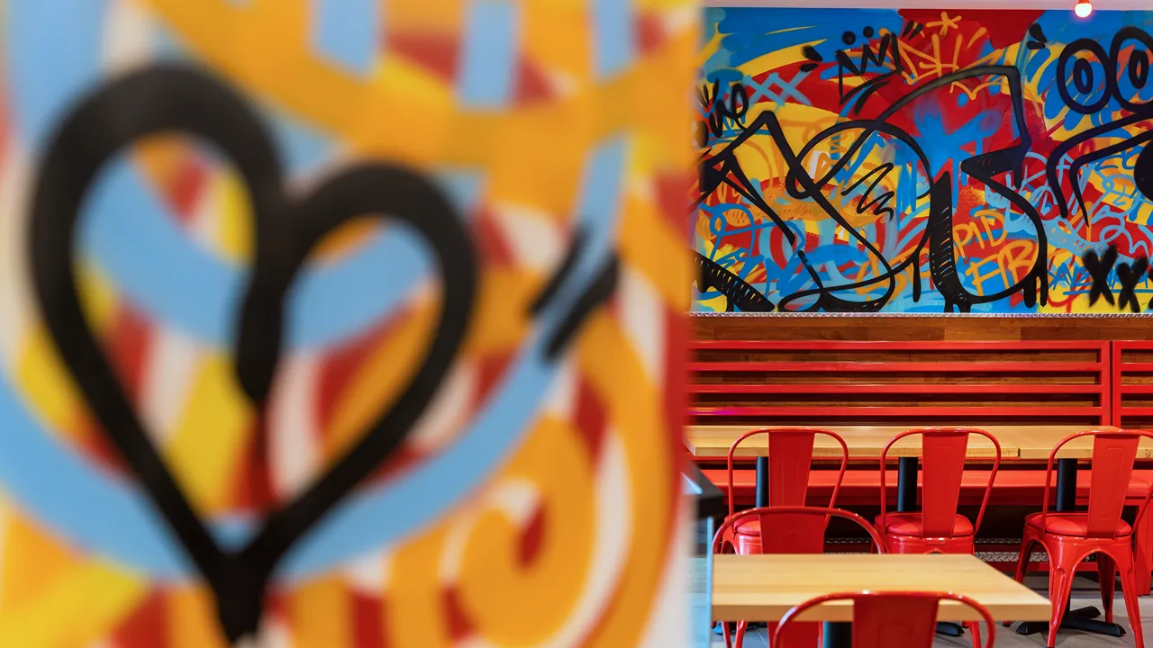 Close-up of colorful wall art at Dave's Hot Chicken, Turin Boulevard Road, Motor City, Dubai.