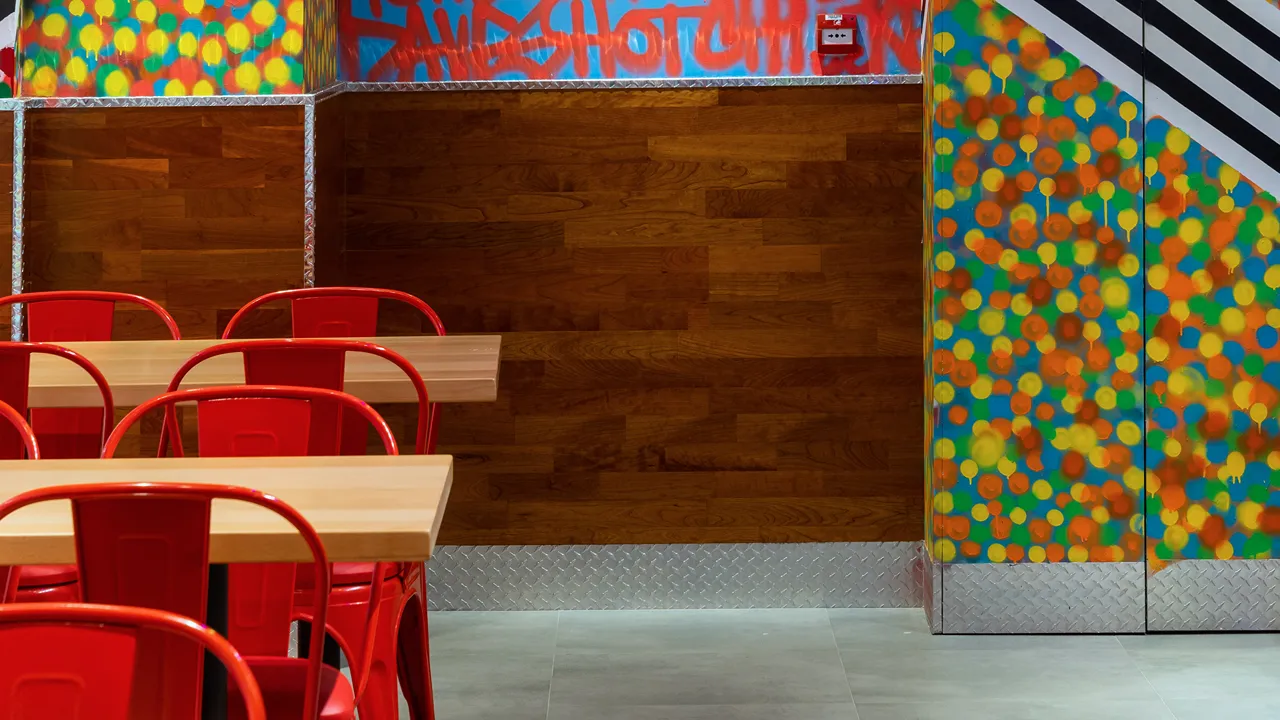 Colorful wall art in the dining area of Dave's Hot Chicken, Turin Boulevard Road, Motor City, Dubai.