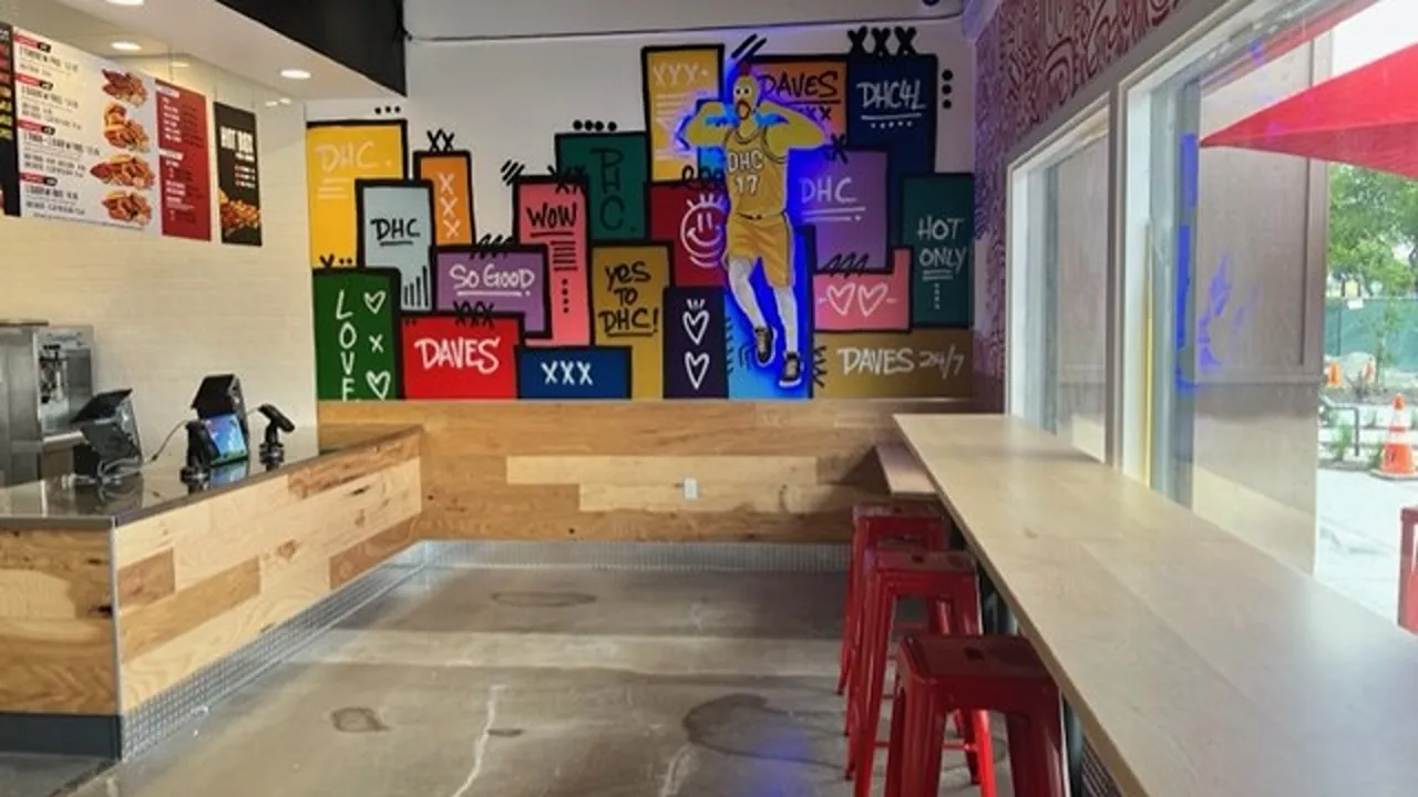 Mural-adorned wall with bar-style seating and counter at Dave’s Hot Chicken on Vintage Way, Novato, CA.