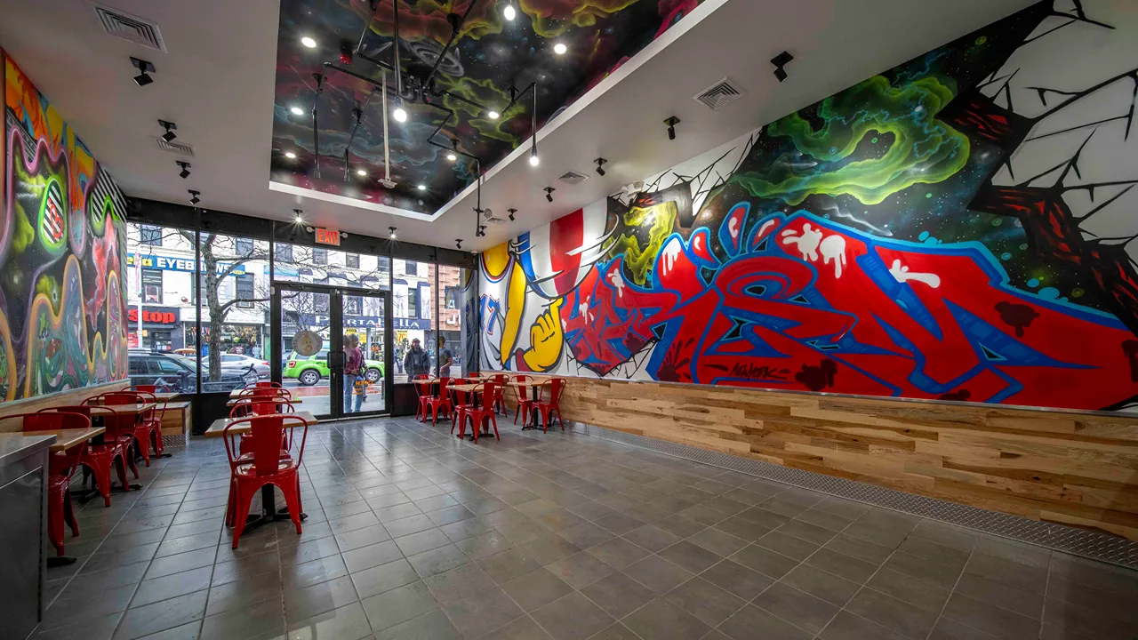 View of the interior featuring street art murals and seating at Dave’s Hot Chicken, W. 125th St., Harlem, New York, NY.