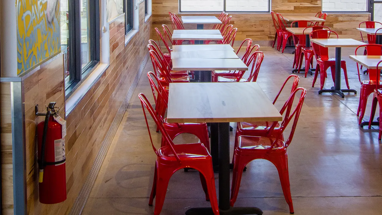 Interior wall art inside Dave's Hot Chicken on W. Costco Dr, Marana, AZ, featuring colorful mural designs near seating.