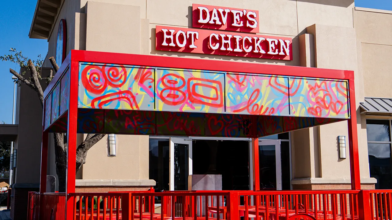 Exterior of Dave's Hot Chicken on W. Expressway 83, McAllen, TX, with colorful patio seating and bold red signage.