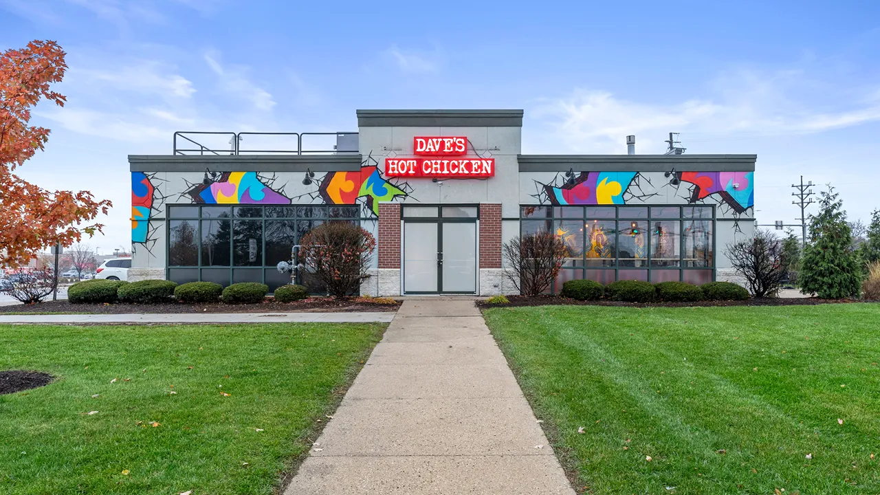 Wide exterior view of the Dave’s Hot Chicken building with colorful murals at the Capitol Dr location in Wauwatosa, WI.