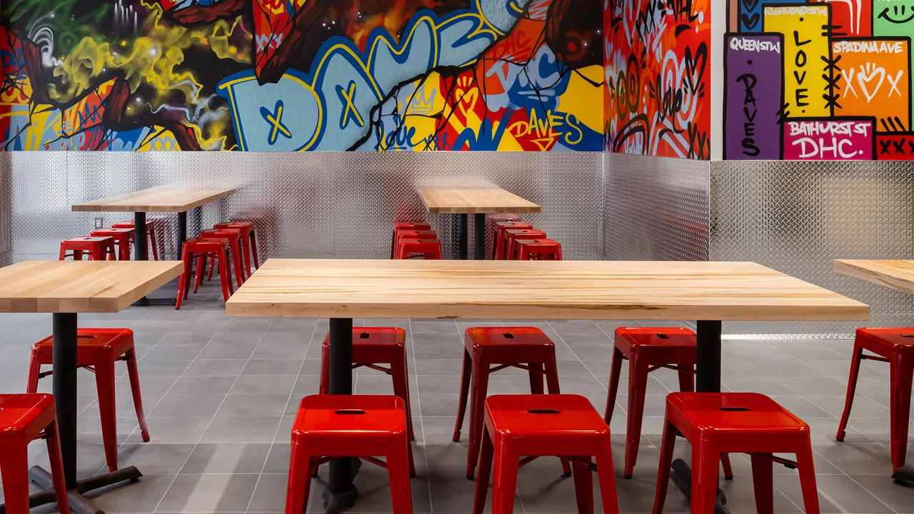 Close-up of red stools and table inside Dave's Hot Chicken on Yonge & Dundas, Toronto, ON.