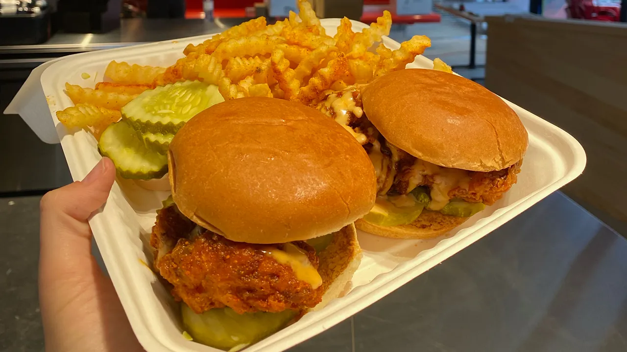 Plate of two Dave's Hot Chicken spicy chicken sandwiches with fries served at the Yonge Street, Midtown, Toronto, ON location.