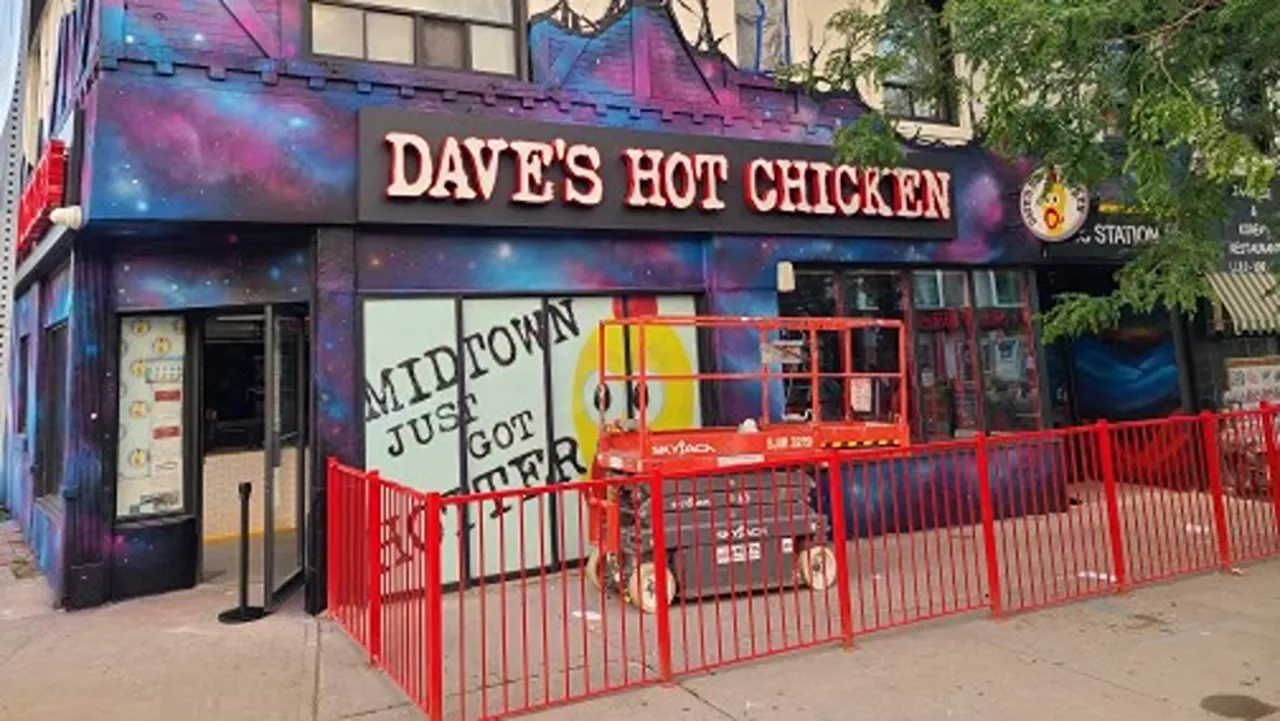 Dave's Hot Chicken restaurant on Yonge Street, Midtown, Toronto, ON, under construction with scaffolding and red fencing visible.