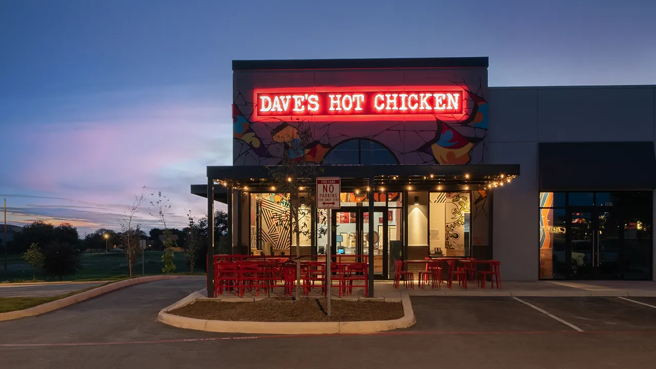 Exterior view of Dave's Hot Chicken with neon signage and outdoor seating at La Picosa on SE Military Drive and South New Braunfels Avenue, San Antonio, TX.