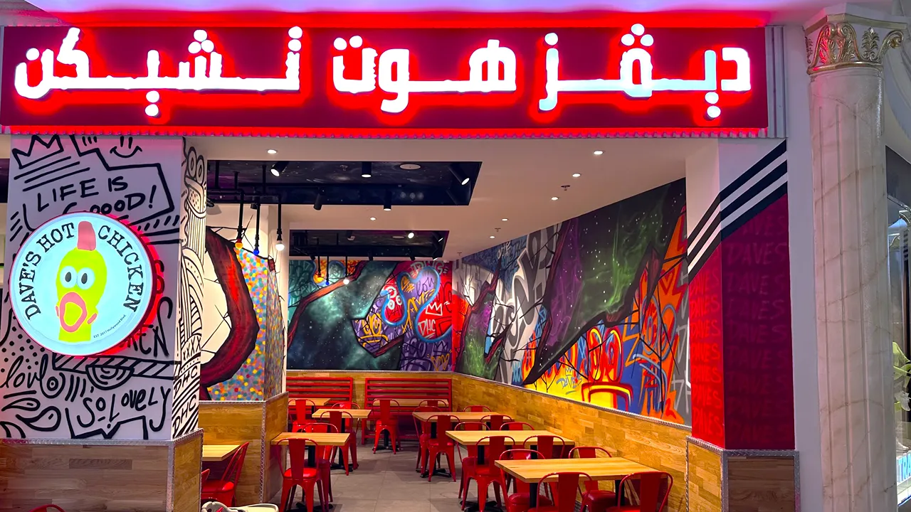Bright red Dave's Hot Chicken signage with Arabic text at Villagio Mall, Doha, Qatar, on Al Waab St.